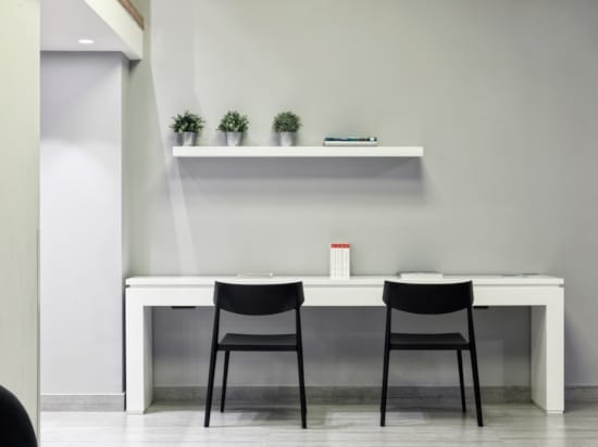 a white table with chairs and a white shelf with plants on it
