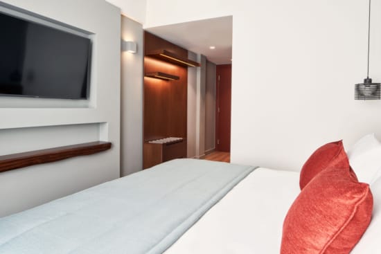 a hotel room with a tv and bed