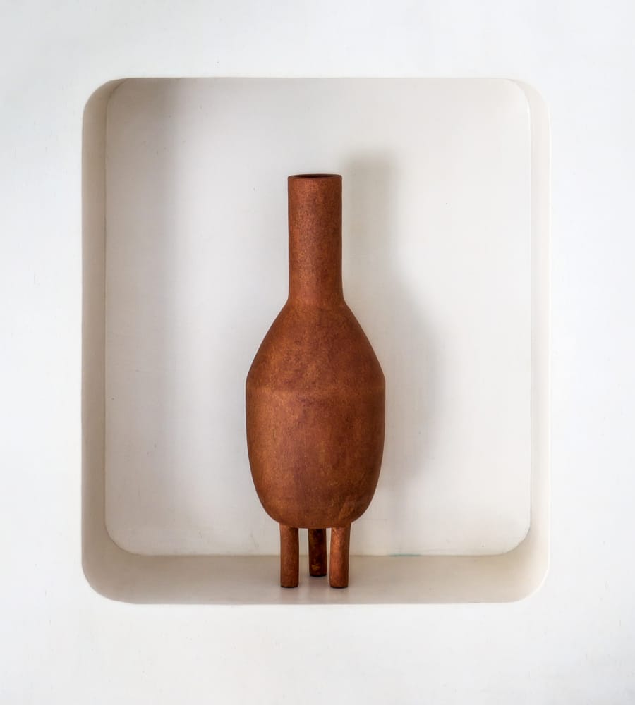 a brown vase on a white surface