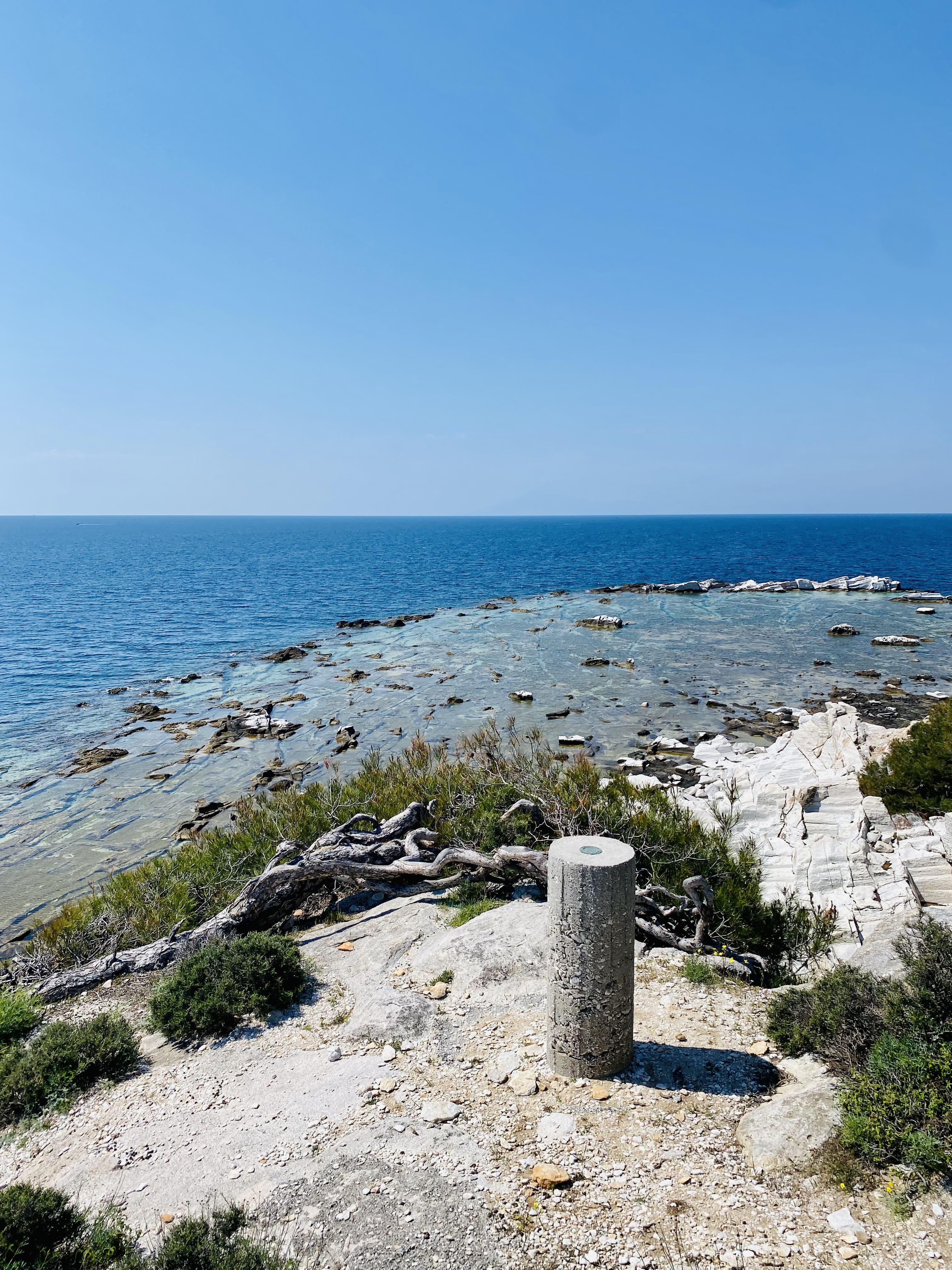 a rocky beach with a stone pillar
