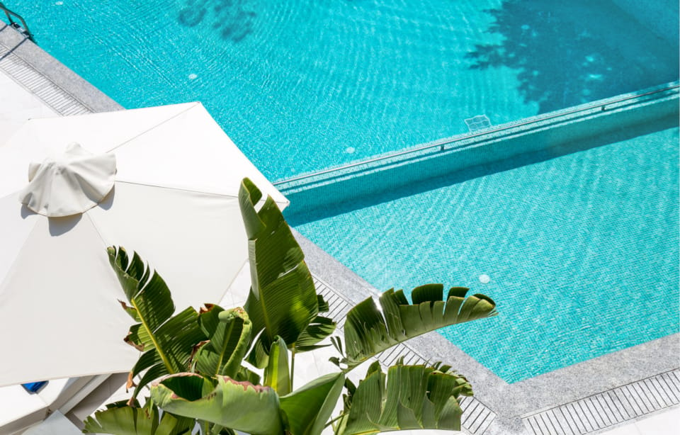 a white umbrella by a pool