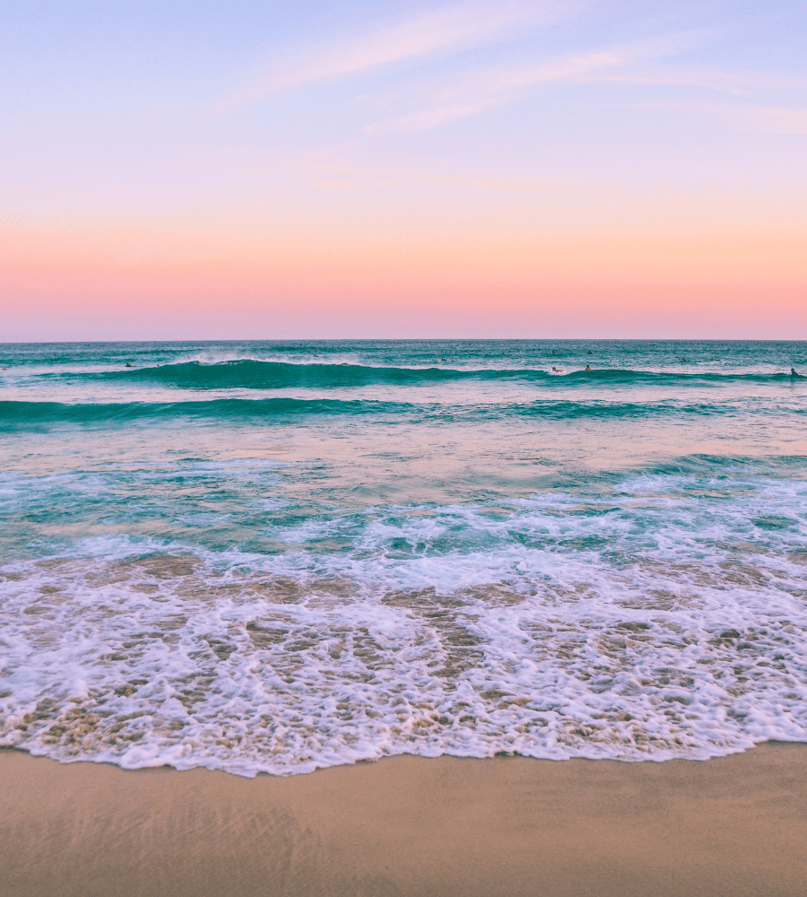 a beach with waves and a sunset