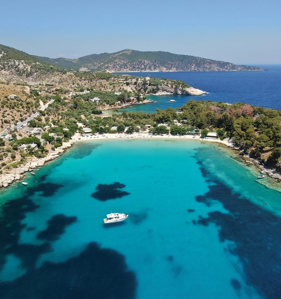 a beach with blue water and a boat on it