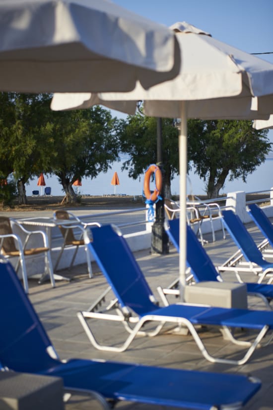 a group of chairs sit under an umbrella