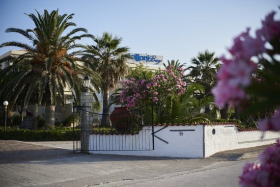 a white fence with trees and a building in the background