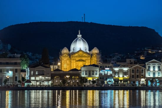 a city with a domed building and a body of water in front of it