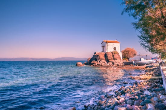 a rocky beach with a building on it