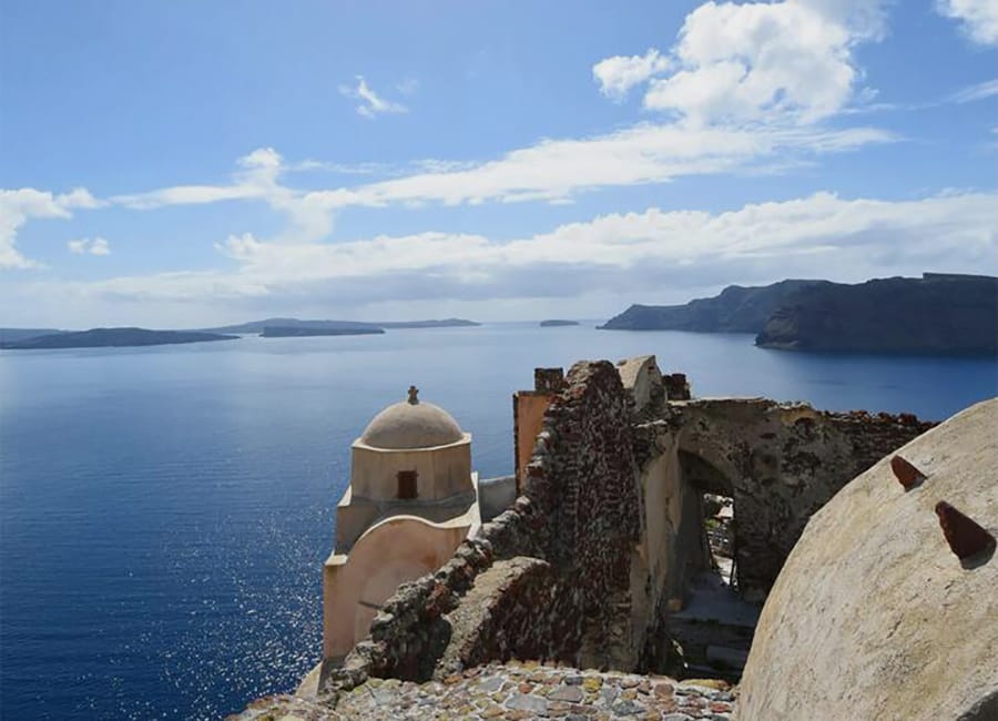 a stone building on a cliff by the water