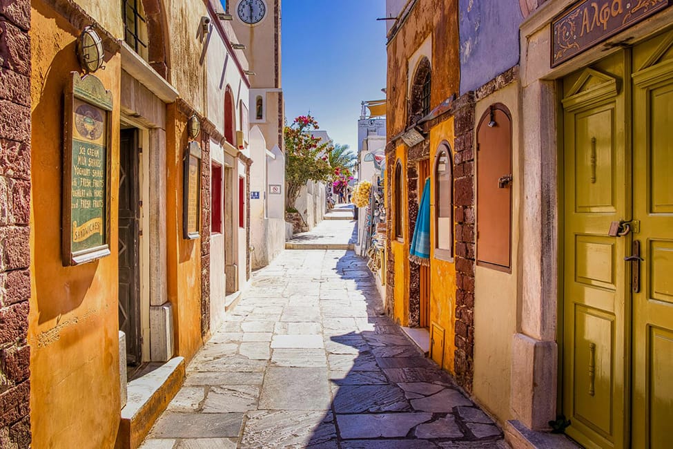a narrow street with yellow doors