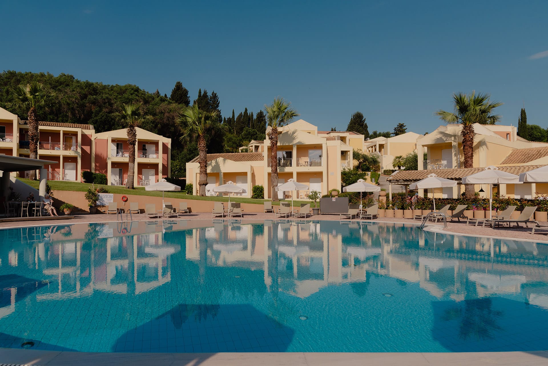 a pool with a few buildings in the background