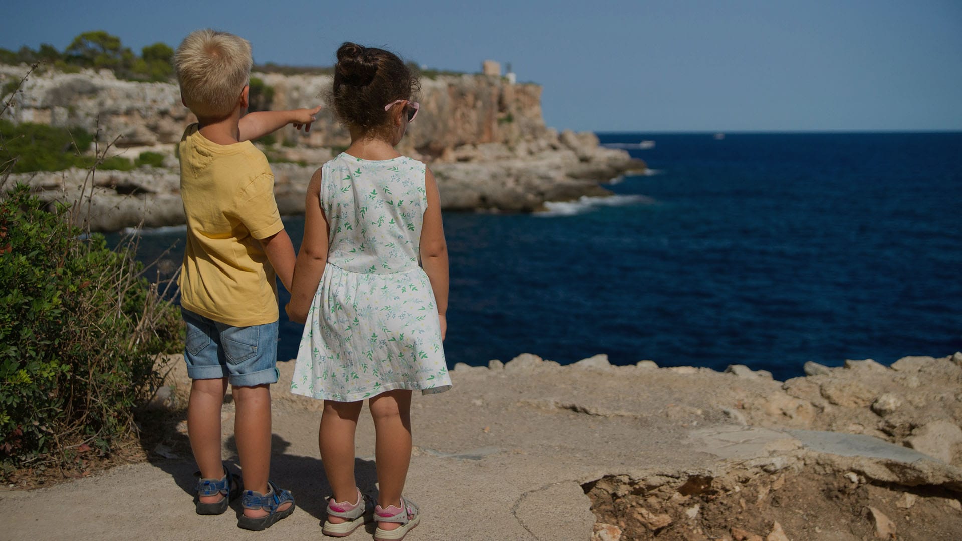 a couple of children looking at the ocean