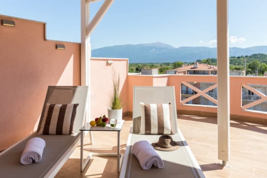 a balcony with a view of the mountains and the ocean