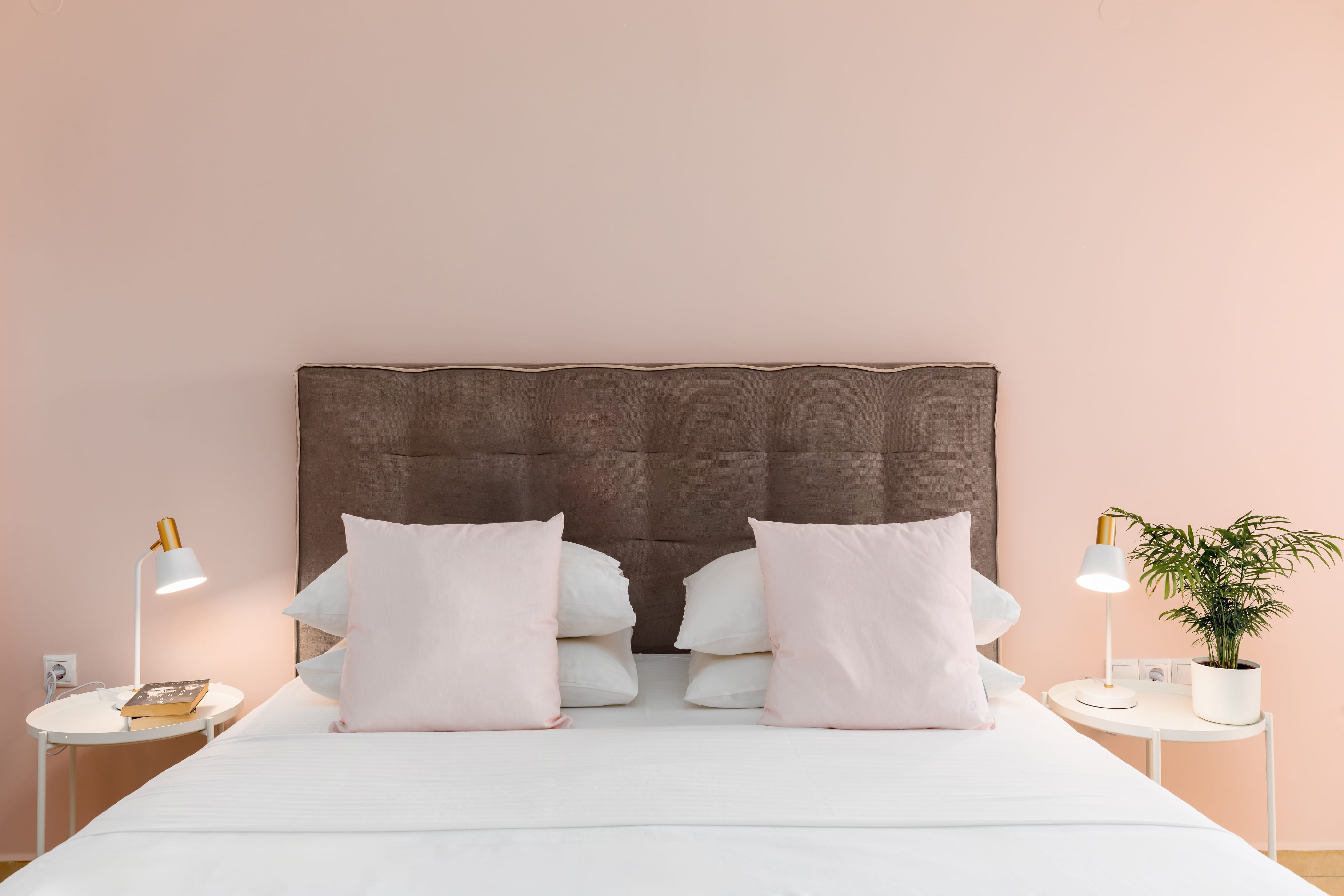 a bed with pillows and lamps