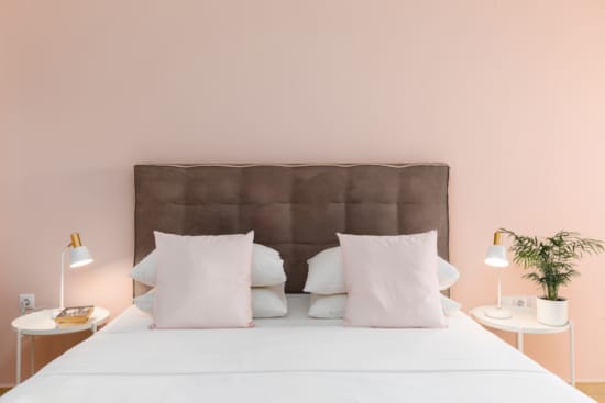 a bed with pillows and lamps