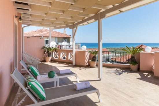 a room with a balcony and a pool