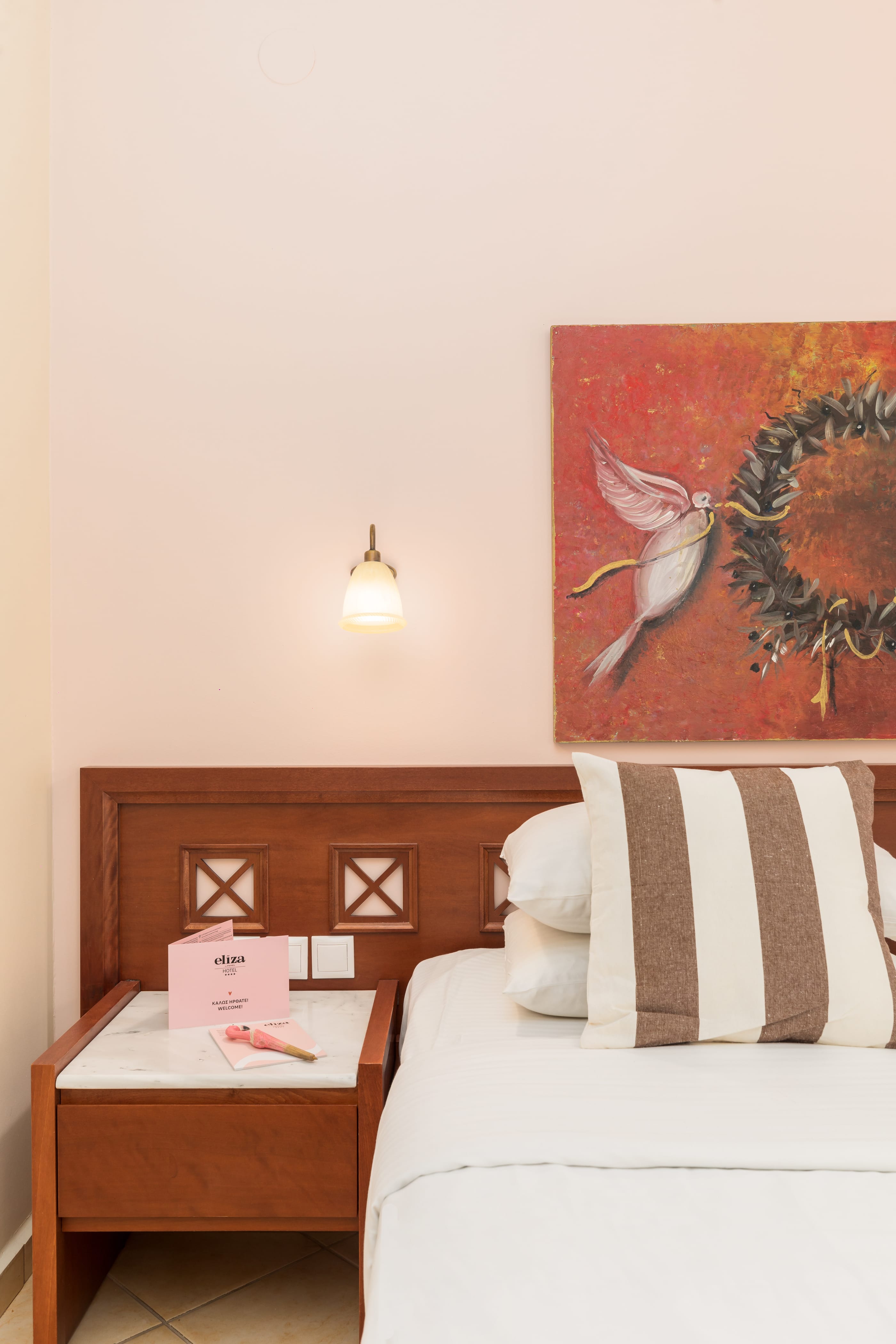 a bed with a pillow and a painting on the wall