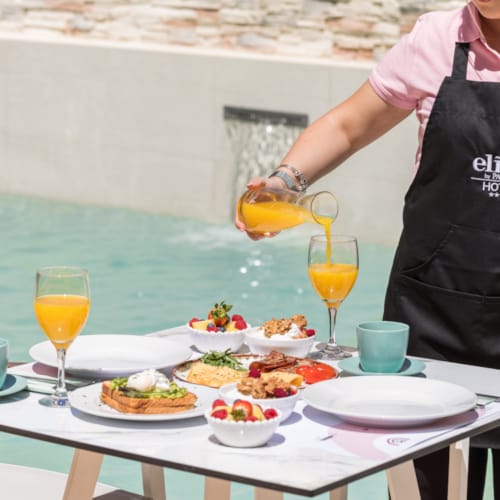 a person pouring a drink into a glass
