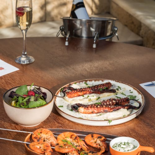 a table with plates of food and a glass of wine