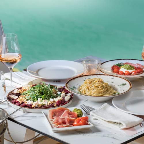 a table with plates of food and glasses of wine