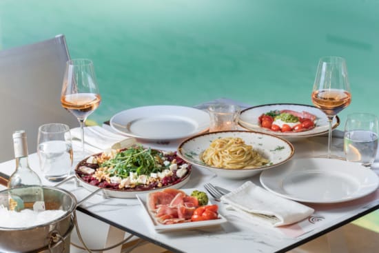 a table with plates of food and glasses of wine