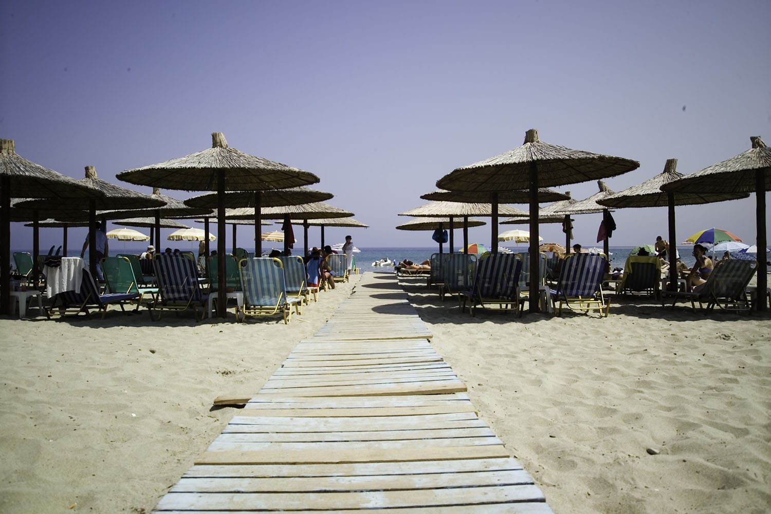 a boardwalk with umbrellas and chairs