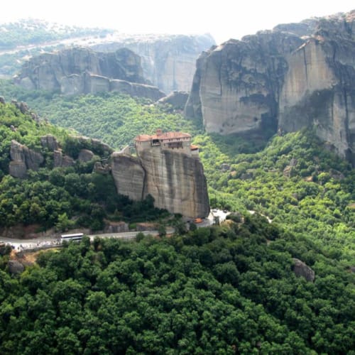 a large rock cliff with a road with Wuyi Mountains in the background
