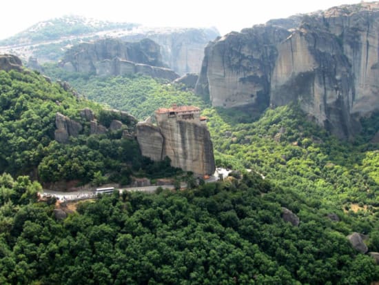 a large rock cliff with a road with Wuyi Mountains in the background