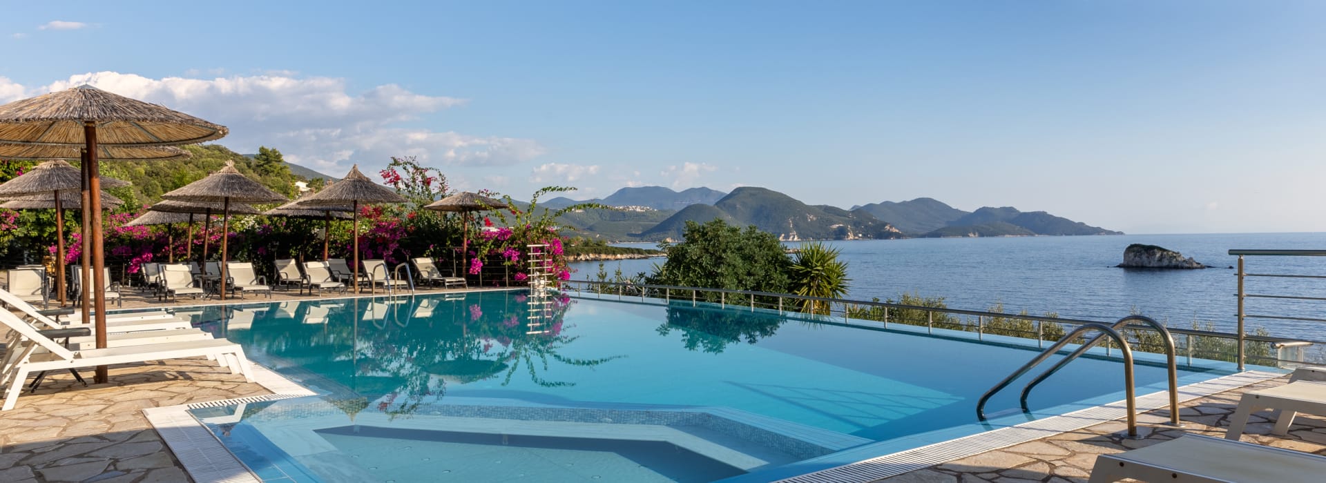 a pool with a deck and umbrellas by it
