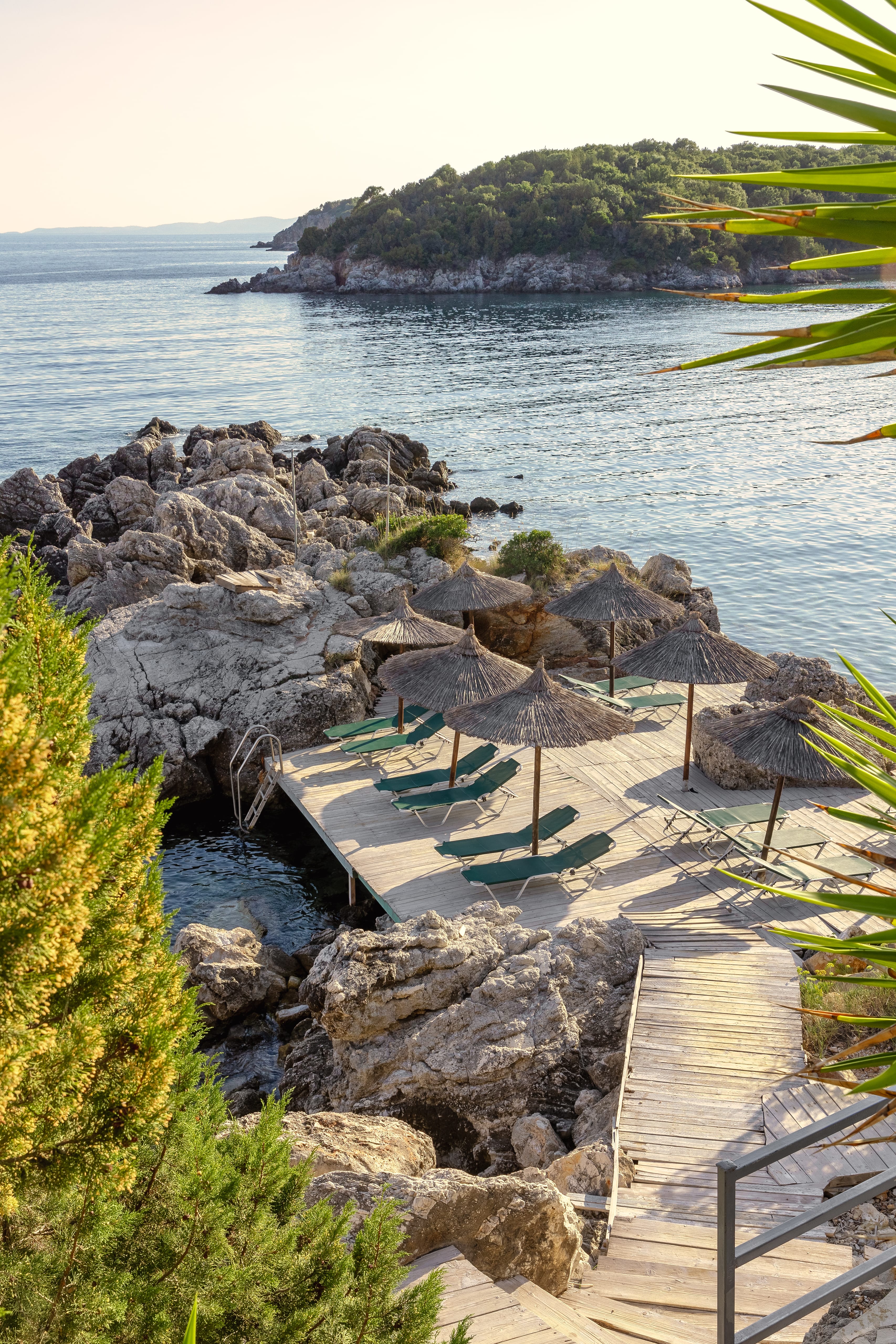 a deck with umbrellas and a body of water in the background