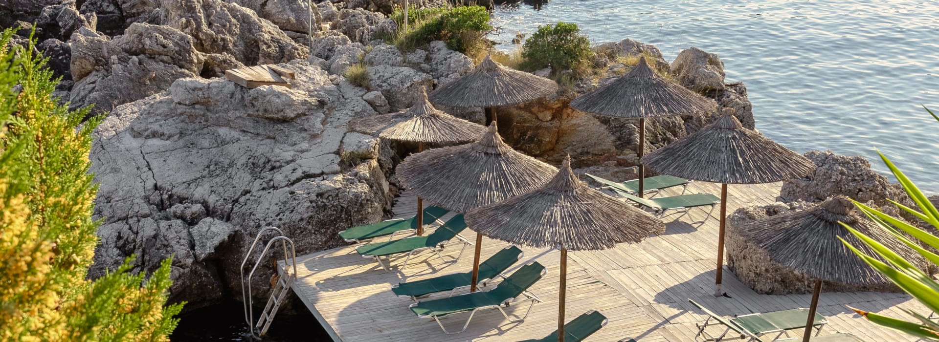 a deck with umbrellas and a body of water in the background