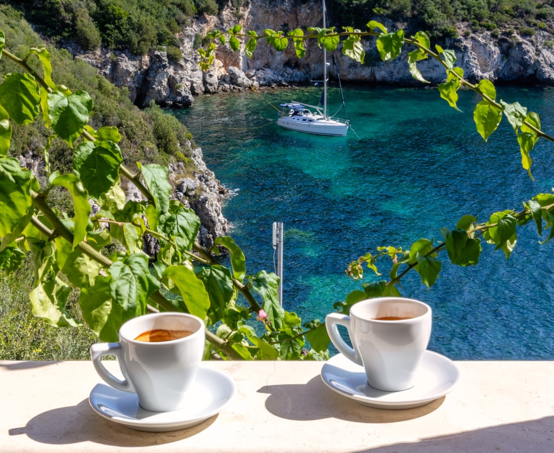 a cup of coffee on a table overlooking a body of water