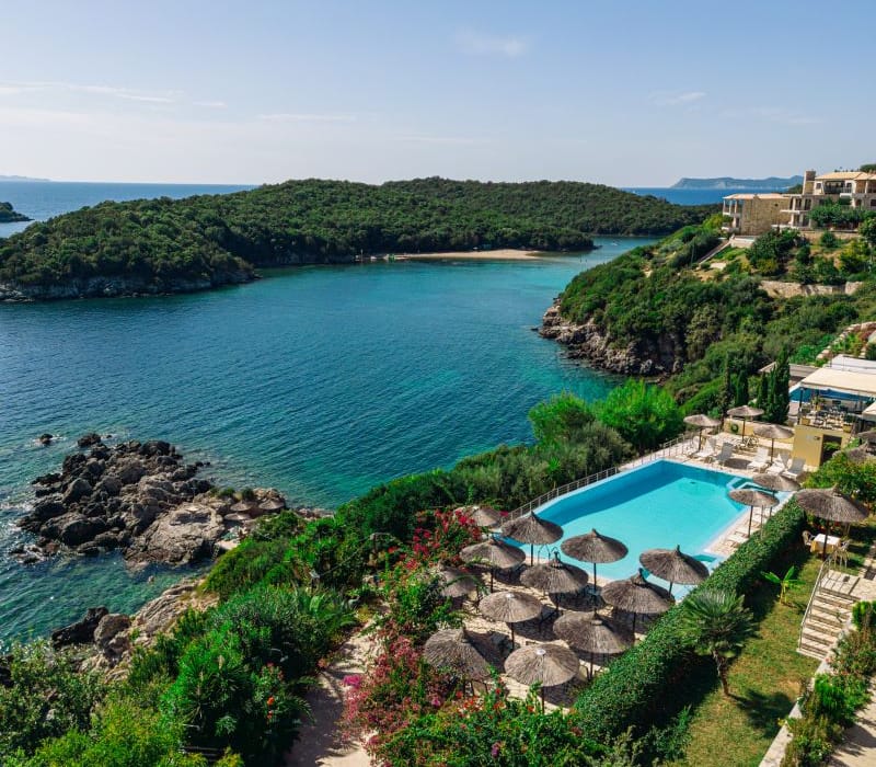 a pool surrounded by trees and a beach
