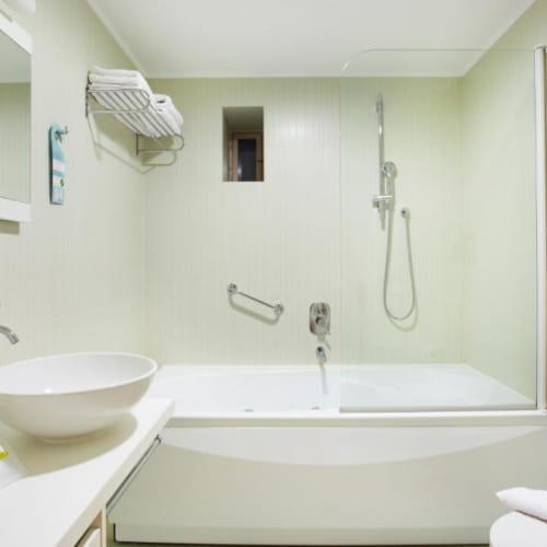 a bathroom with a tub sink and a mirror