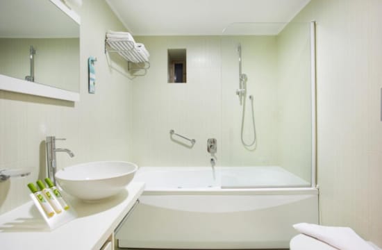 a bathroom with a tub sink and a mirror