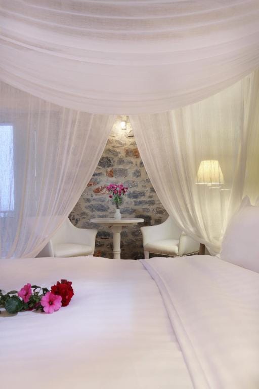 a room with a bed and a table with flowers on it