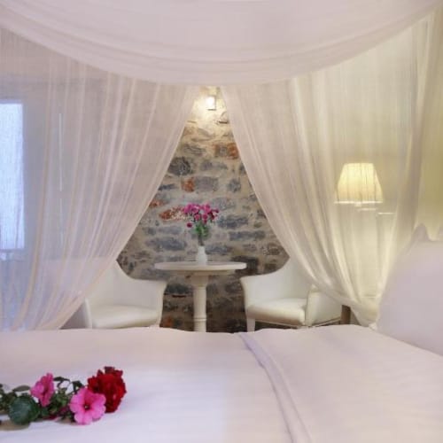 a room with a bed and a table with flowers on it