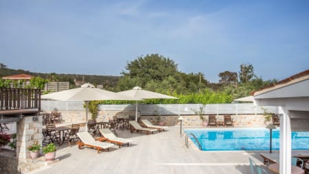 a swimming pool with lounge chairs and umbrellas