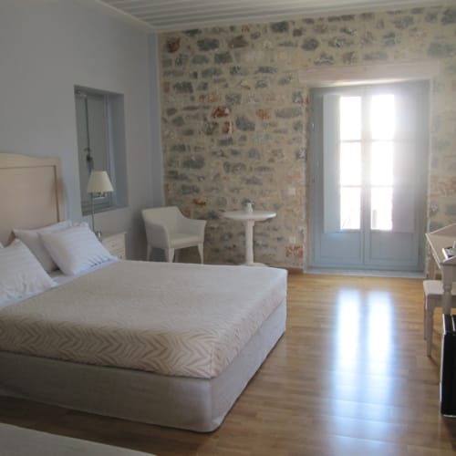 a bedroom with a bed and chairs