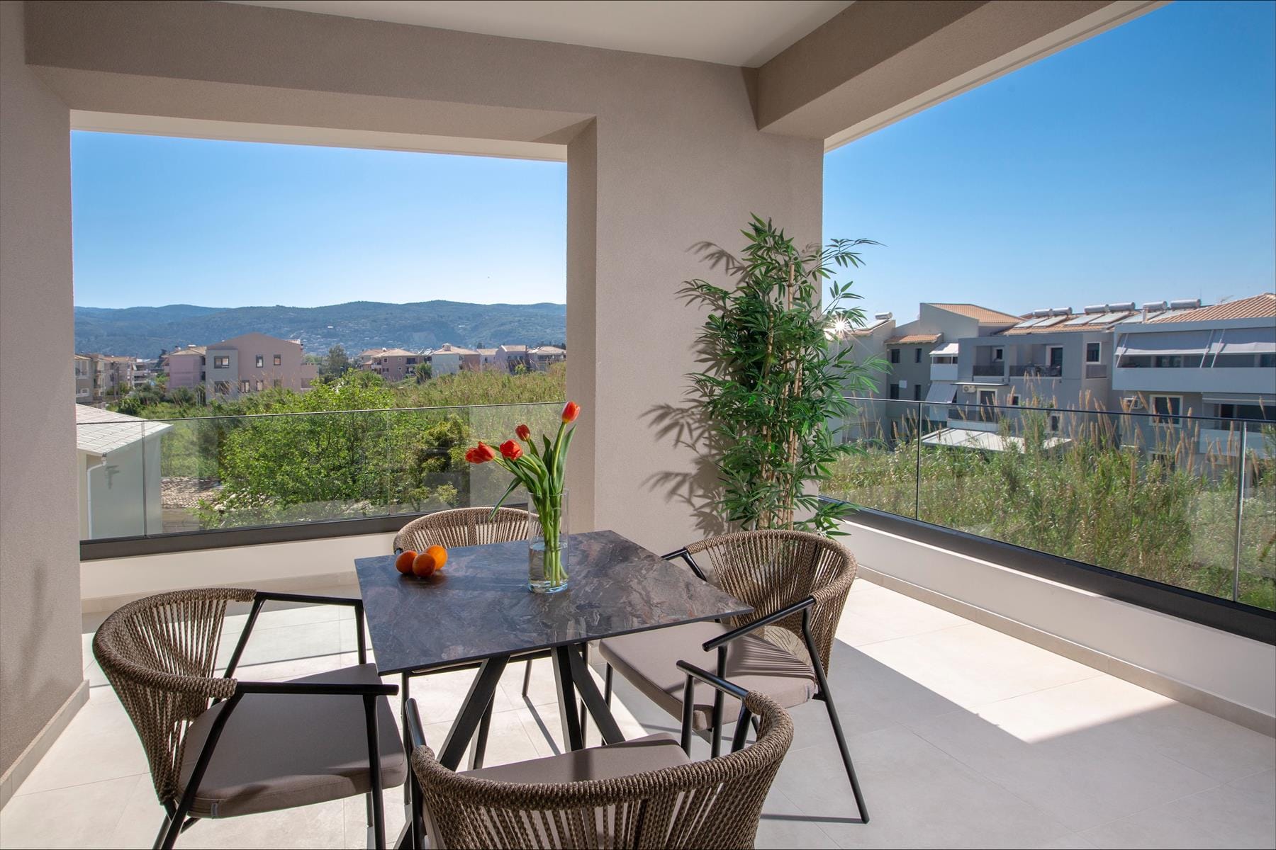 a table with chairs and a vase of flowers on it by a window