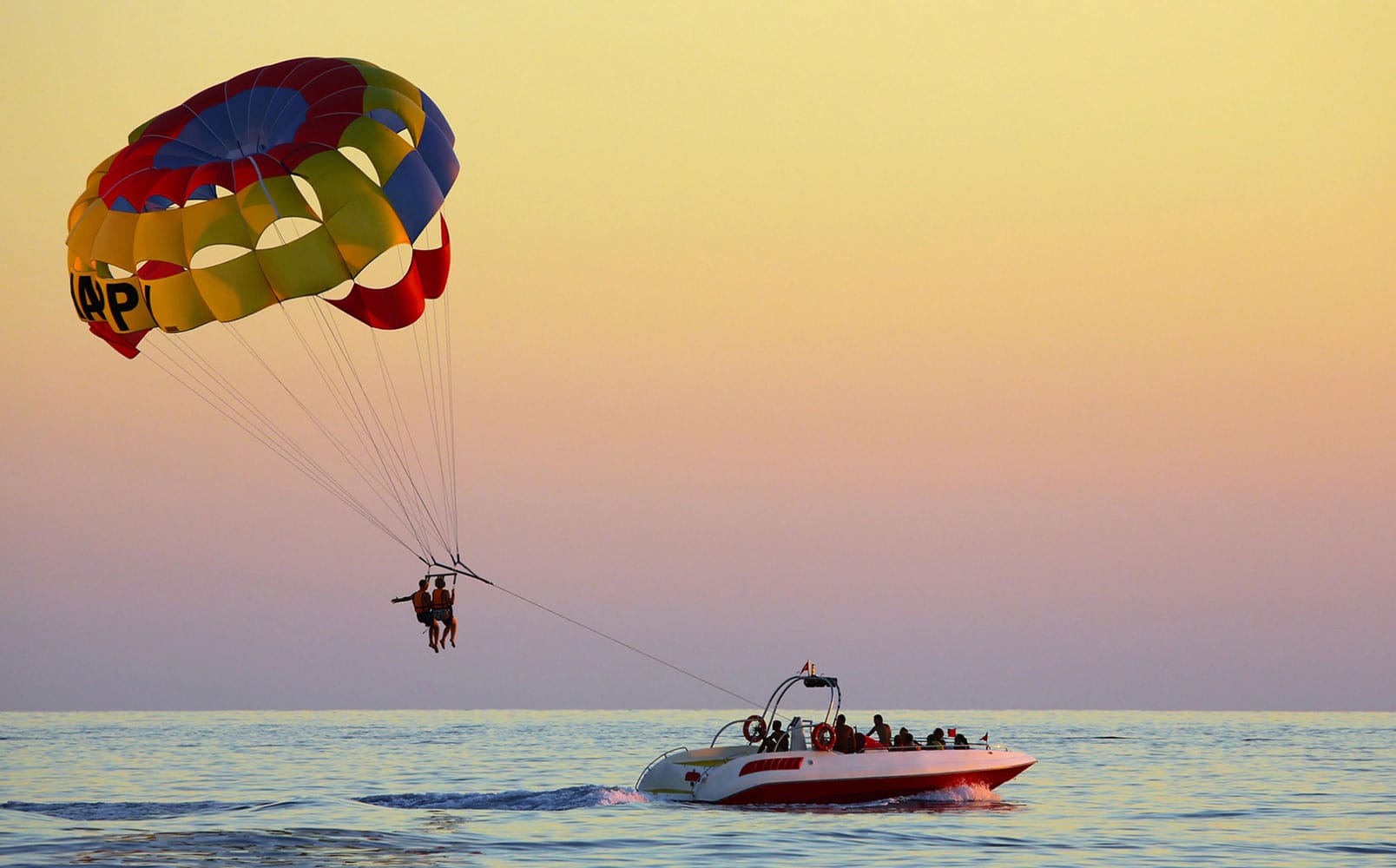 a person parasailing over a boat