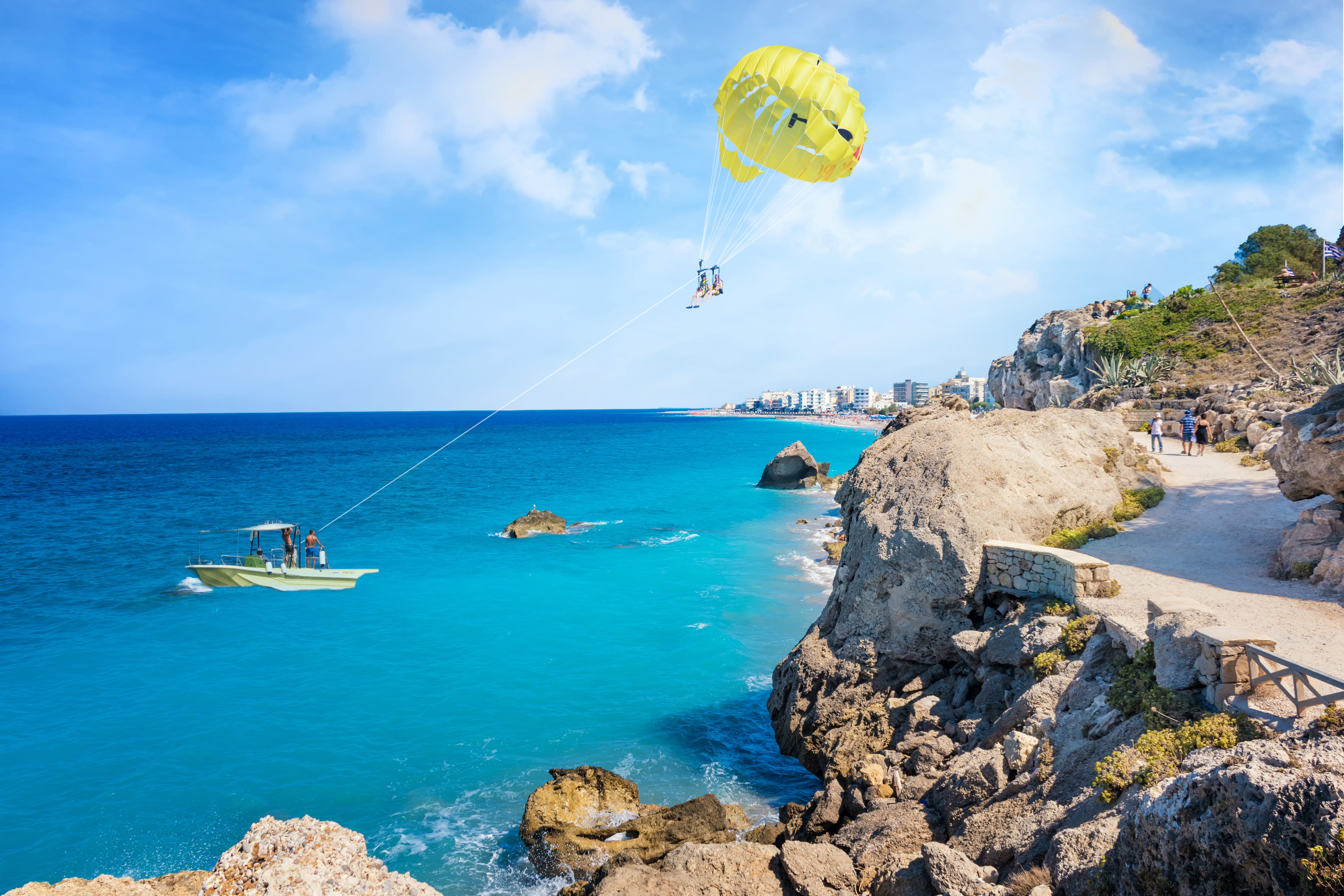 a beach with a boat and a parachute in the air