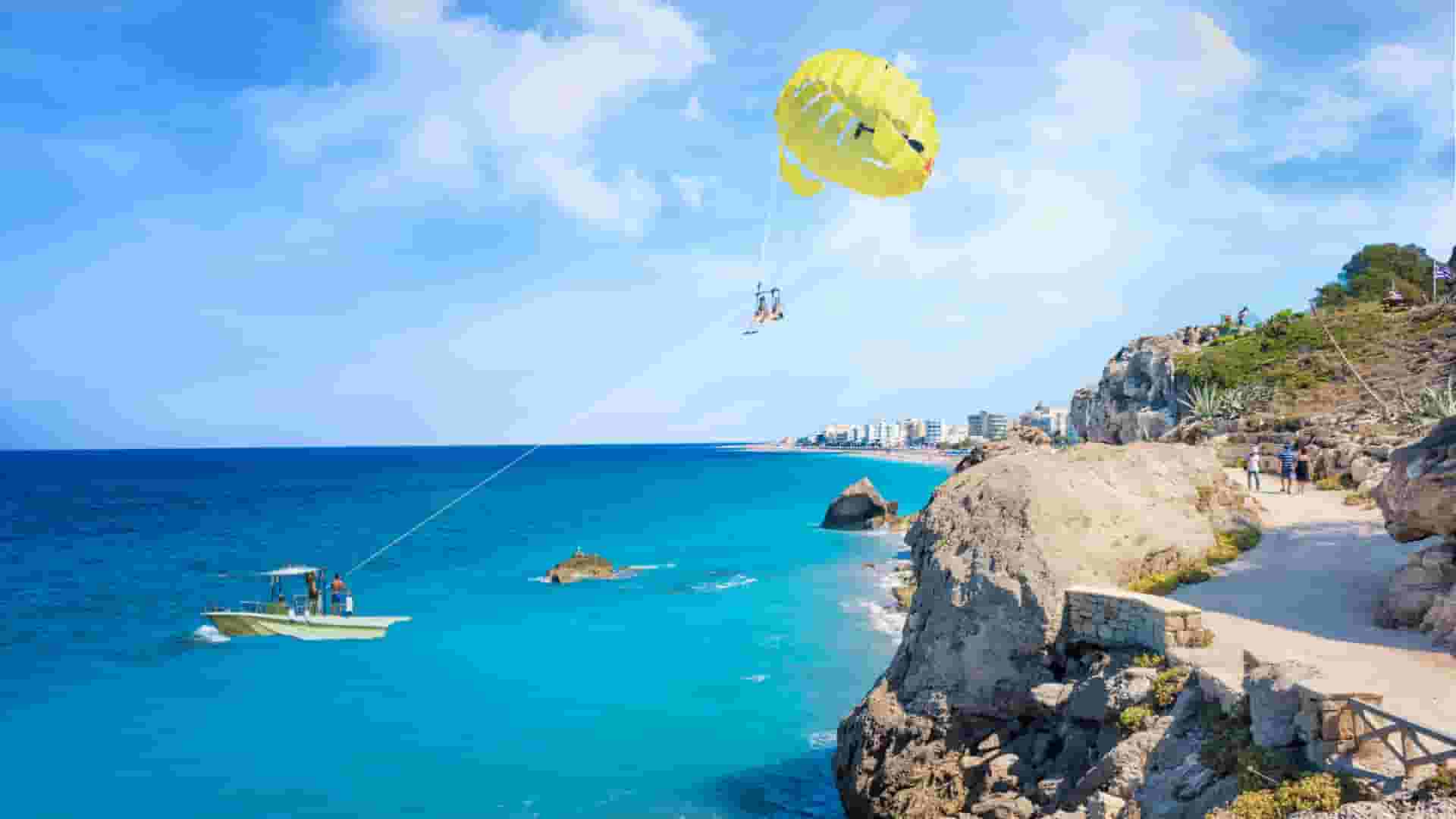 a beach with a boat and a parachute in the air