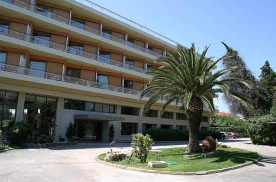 a building with palm trees and a fountain in front of it