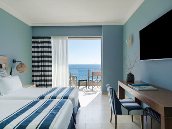 a bedroom with a bed desk and a tv