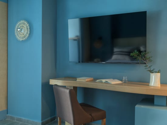 a desk with a chair and a television in the background