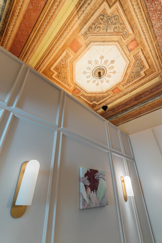 a ceiling with a clock and lamps