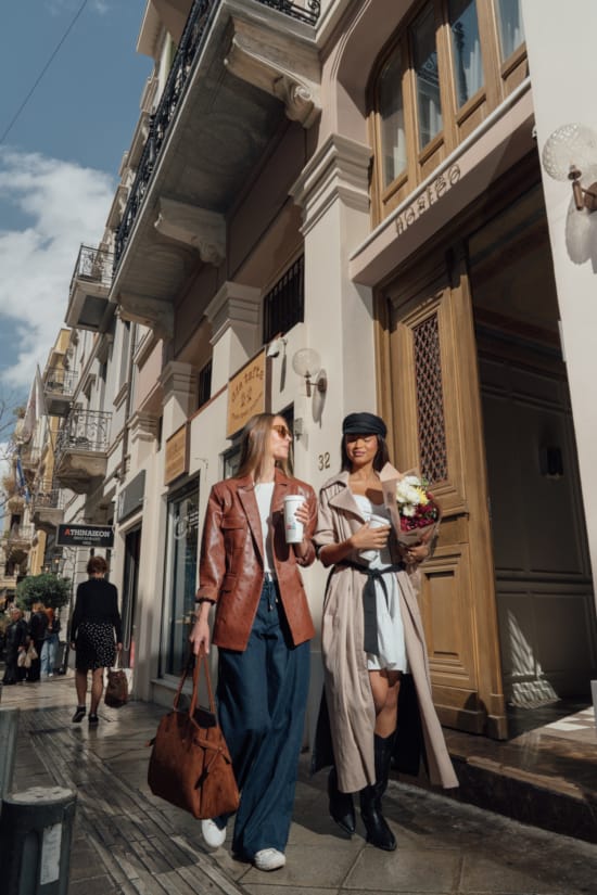 a couple of women posing for a picture outside of a building