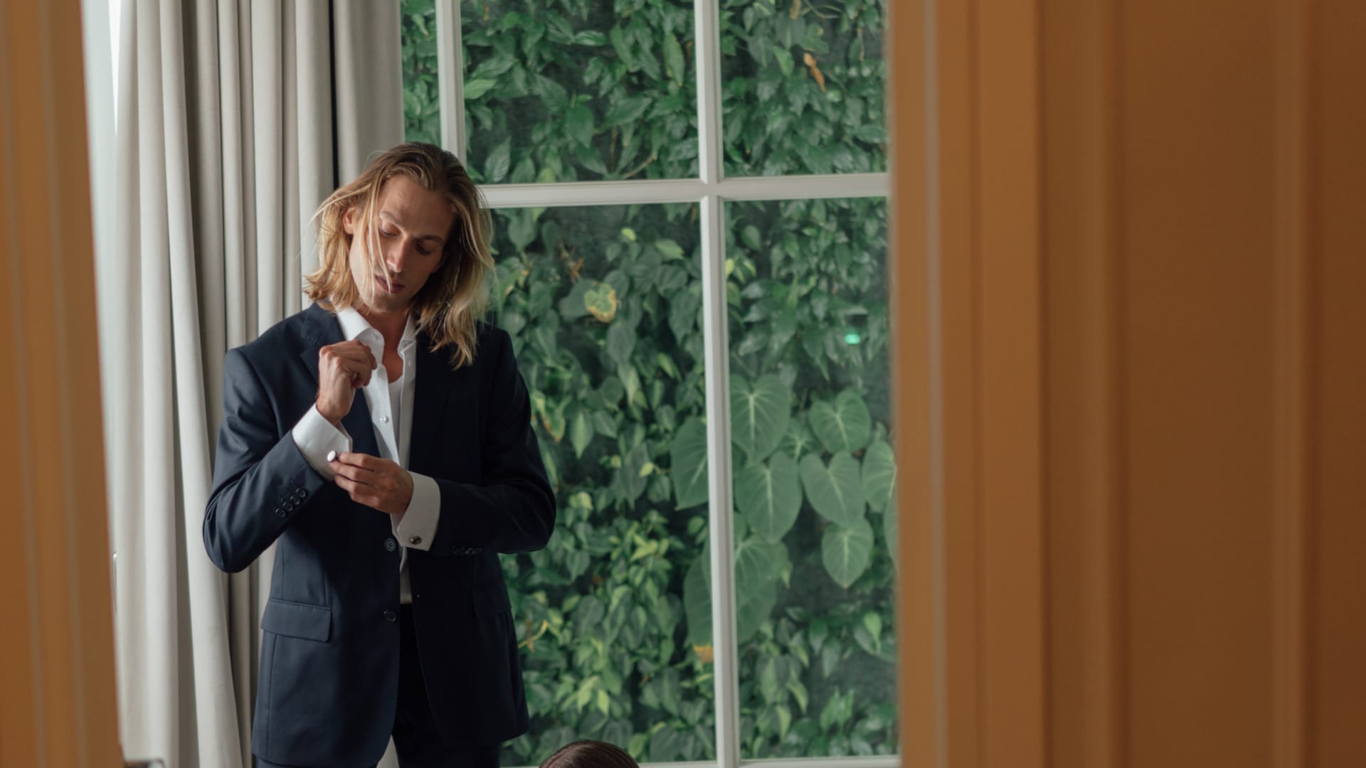 a woman sitting on the floor next to a man standing in a doorway