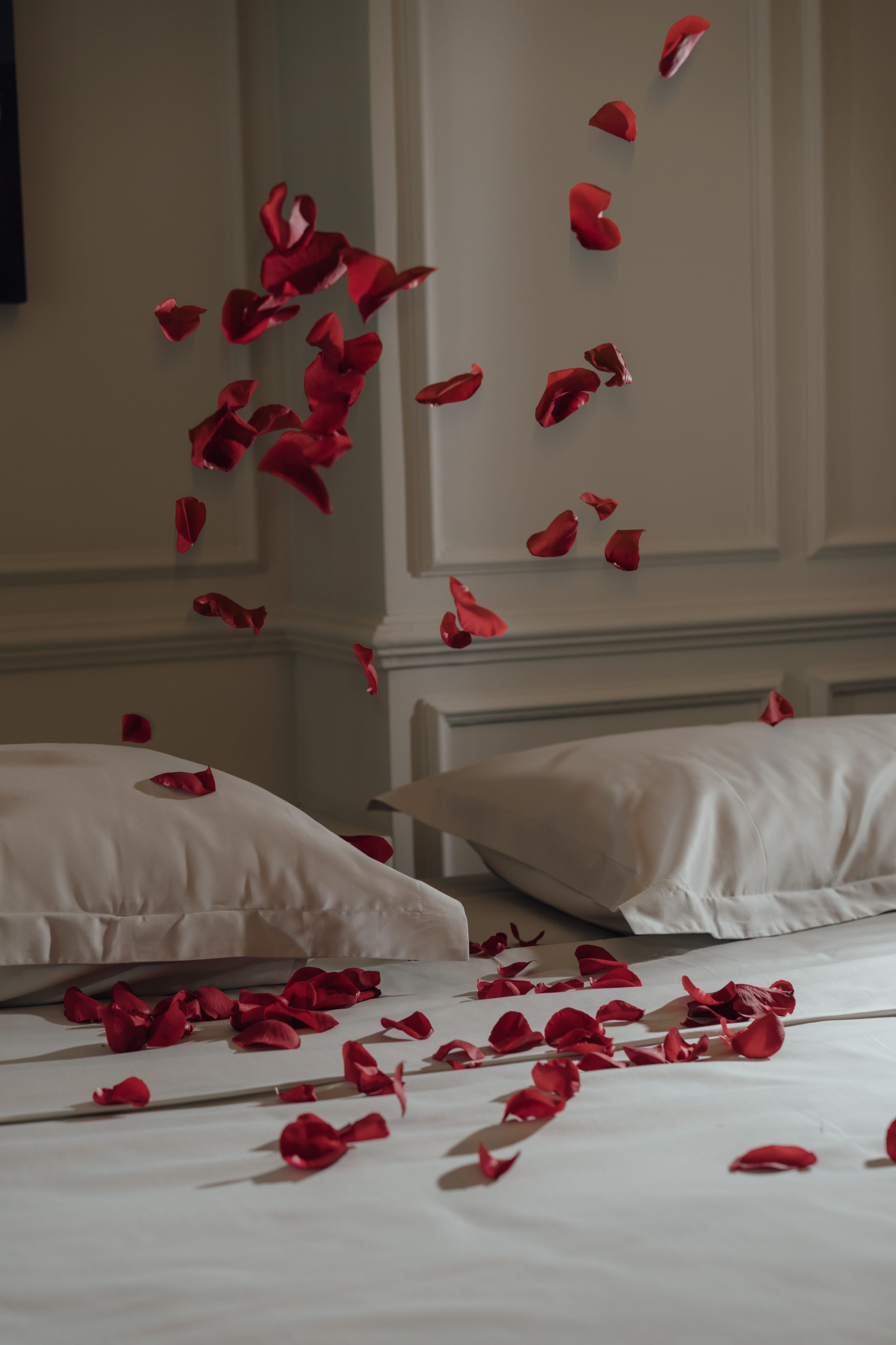 a bed with a white bed spread and red hearts on it