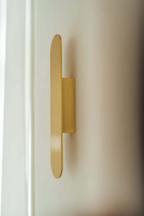 a yellow pencil leaning against a white wall